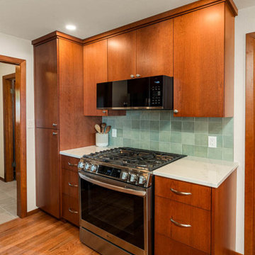Elegant Cooking Area with Soft Green Tile Backsplash