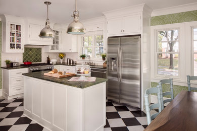 Traditional l-shaped eat-in kitchen in Milwaukee with a farmhouse sink, shaker cabinets, white cabinets, green splashback, subway tile splashback, stainless steel appliances and with island.