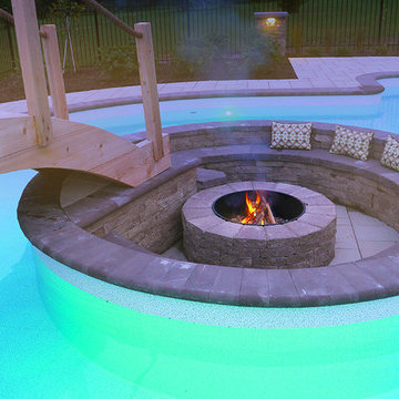 Pool with a firepit by Exact Landscapes