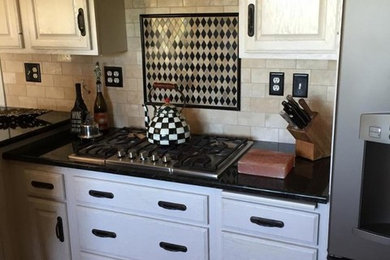 Example of a classic medium tone wood floor and brown floor kitchen design in Chicago with raised-panel cabinets, white cabinets, quartz countertops, beige backsplash, subway tile backsplash and stainless steel appliances