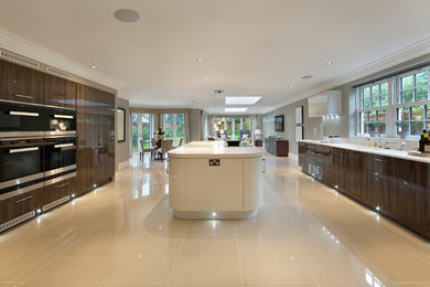 Example of a large minimalist galley porcelain tile eat-in kitchen design in Miami with an integrated sink, flat-panel cabinets, dark wood cabinets, quartzite countertops, stainless steel appliances and an island
