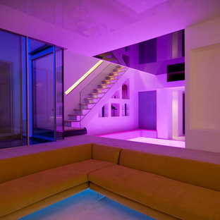 Large contemporary basement in London with white walls and light hardwood flooring.