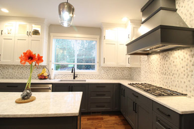Example of a large transitional l-shaped medium tone wood floor and brown floor open concept kitchen design in Seattle with an undermount sink, recessed-panel cabinets, gray cabinets, quartz countertops, multicolored backsplash, ceramic backsplash, stainless steel appliances, an island and white countertops