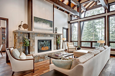 Example of a huge mountain style open concept medium tone wood floor living room design in Vancouver with white walls, a standard fireplace, a stone fireplace and no tv