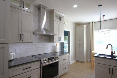 Example of a minimalist kitchen design in Atlanta with shaker cabinets and quartz countertops