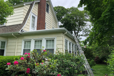 Inspiration for a large 1950s yellow two-story wood exterior home remodel in Boston with a tile roof