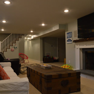 This is an example of a medium sized modern fully buried basement in Boston with green walls, carpet and a standard fireplace.
