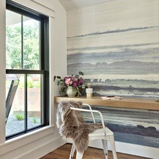 Exempel på ett lantligt hemmabibliotek, med flerfärgade väggar, ljust trägolv, ett inbyggt skrivbord och beiget golv