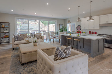 Example of a mid-sized trendy galley vinyl floor and beige floor open concept kitchen design in San Francisco with an undermount sink, recessed-panel cabinets, white cabinets, marble countertops, white backsplash, glass tile backsplash, stainless steel appliances, an island and white countertops