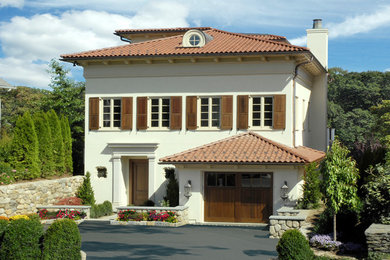 Inspiration for a mediterranean white two-story exterior home remodel in New York with a hip roof