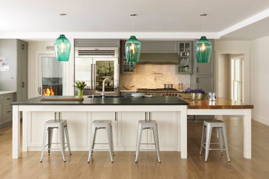 Inspiration for a transitional l-shaped medium tone wood floor and brown floor kitchen remodel in Other with shaker cabinets, gray cabinets, white backsplash, mosaic tile backsplash, stainless steel appliances and an island