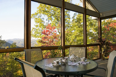 This is an example of a large modern screened-in back porch design in Other with decking and a roof extension.