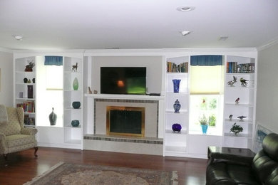 他の地域にある広いトラディショナルスタイルのおしゃれなLDK (ベージュの壁、無垢フローリング、標準型暖炉、タイルの暖炉まわり、壁掛け型テレビ) の写真