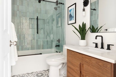 1960s 3/4 blue tile and porcelain tile cement tile floor, multicolored floor and single-sink bathroom photo in Salt Lake City with flat-panel cabinets, medium tone wood cabinets, white walls, an undermount sink, white countertops, a niche, a freestanding vanity and a one-piece toilet