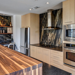 ダラスの中サイズのコンテンポラリースタイルのおしゃれなコの字型キッチン (フラットパネル扉のキャビネット、淡色木目調キャビネット、マルチカラーのキッチンパネル、シルバーの調理設備の) の写真