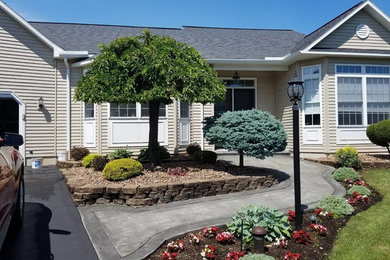 Inspiration for a mid-sized transitional beige one-story vinyl exterior home remodel in New York with a shingle roof