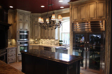 Example of a classic kitchen design in Oklahoma City with raised-panel cabinets, distressed cabinets and granite countertops