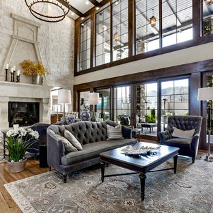 Geräumiges, Abgetrenntes Mediterranes Wohnzimmer mit gelber Wandfarbe, hellem Holzboden, Kamin, Kaminsims aus Stein, verstecktem TV und braunem Boden in Denver