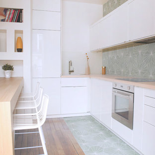 Mittelgroße Moderne Küche in L-Form mit weißen Schränken, Arbeitsplatte aus Holz, bunter Rückwand, Rückwand aus Zementfliesen, Halbinsel, flächenbündigen Schrankfronten und Küchengeräten aus Edelstahl in Paris