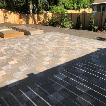Raised holland patio and walkway with manor stone wall
