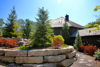 This is an example of a huge rustic backyard retaining wall landscape in Edmonton.