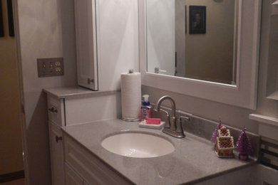 Transitional gray tile and porcelain tile porcelain tile doorless shower photo in Chicago with recessed-panel cabinets, white cabinets, a one-piece toilet, gray walls, an undermount sink and onyx countertops