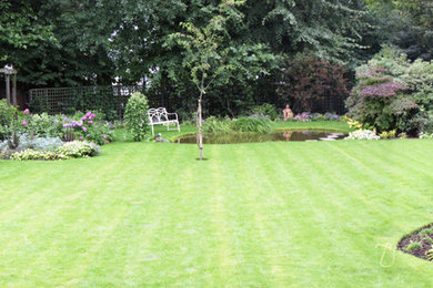This is an example of a mid-sized traditional partial sun backyard landscaping in London for summer.