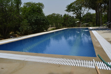 Inspiration for a mid-sized modern backyard rectangular aboveground pool remodel in Delhi with decking