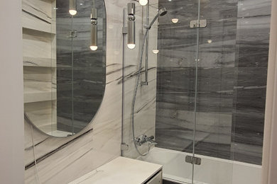 Стильный дизайн: главная ванная комната среднего размера в классическом стиле с полновстраиваемой ванной, керамогранитной плиткой, полом из керамогранита, серым полом, душем с распашными дверями, гигиеническим душем, тумбой под одну раковину, подвесной тумбой и многоуровневым потолком - последний тренд