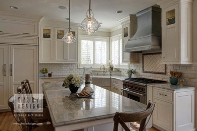 Traditional l-shaped eat-in kitchen in Chicago with a farmhouse sink, beaded inset cabinets, white cabinets, white splashback, subway tile splashback, stainless steel appliances, light hardwood floors and with island.