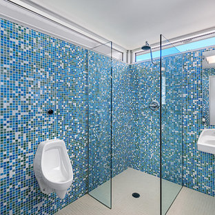 Esempio di una stanza da bagno minimalista di medie dimensioni con doccia a filo pavimento, orinatoio, piastrelle blu, piastrelle in ceramica, pavimento con piastrelle in ceramica e lavabo sospeso