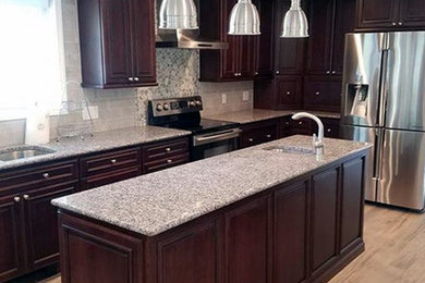 Kitchen pantry - large traditional l-shaped kitchen pantry idea in Other with an undermount sink, raised-panel cabinets, dark wood cabinets, quartz countertops, beige backsplash, ceramic backsplash, stainless steel appliances, an island and beige countertops