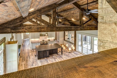 Country u-shaped light wood floor open concept kitchen photo in Other with a farmhouse sink, shaker cabinets, gray cabinets, granite countertops, gray backsplash, paneled appliances, an island and subway tile backsplash