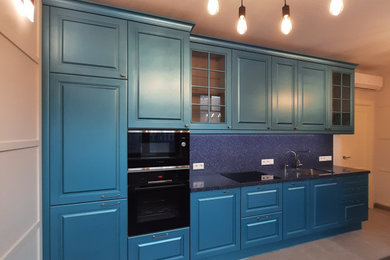 Diseño de cocina comedor lineal clásica renovada sin isla con fregadero bajoencimera, armarios con paneles con relieve, puertas de armario azules y encimera de acrílico