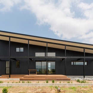 他の地域のコンテンポラリースタイルのおしゃれな家の外観 (木材サイディング、黒い外壁、陸屋根、戸建、金属屋根) の写真