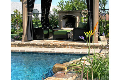 This is an example of a mid-sized transitional backyard patio in Dallas with natural stone pavers and a pergola.