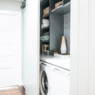 Inspiration for a small contemporary single-wall laundry cupboard in San Francisco with open cabinets, grey cabinets, composite countertops, grey walls, medium hardwood flooring and a side by side washer and dryer.