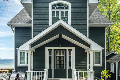 Photo of a mid-sized beach style two-storey blue exterior in Toronto with wood siding.
