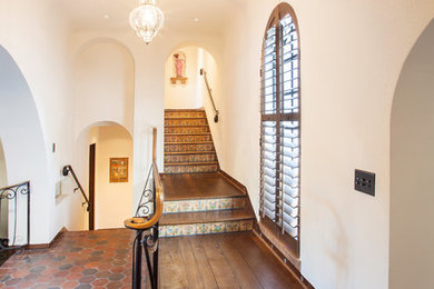 Large tuscan wooden l-shaped staircase photo in Seattle with tile risers