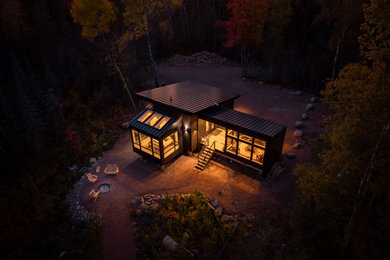 Small mountain style black one-story house exterior photo in Minneapolis with a shed roof, a metal roof and a black roof