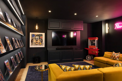 Modelo de cine en casa cerrado contemporáneo grande con paredes azules, suelo de madera en tonos medios, pared multimedia y suelo beige
