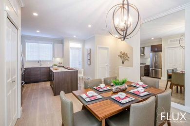 Inspiration for a modern l-shaped light wood floor eat-in kitchen remodel in Los Angeles with an undermount sink, flat-panel cabinets, medium tone wood cabinets, quartz countertops, white backsplash, ceramic backsplash, stainless steel appliances and an island