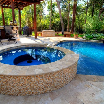 Natural Pool with rock waterfall, bridge, spa, and pergola