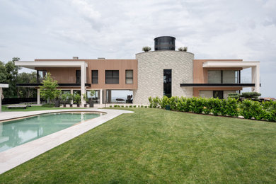 Immagine della villa marrone contemporanea a due piani con rivestimenti misti e tetto piano