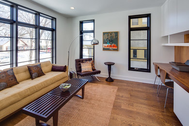 Example of a mid-sized minimalist open concept medium tone wood floor family room library design in Minneapolis with gray walls, no fireplace and no tv