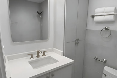 Alcove bathtub - small contemporary kids' porcelain tile, gray floor and single-sink alcove bathtub idea in Chicago with flat-panel cabinets, gray cabinets, a one-piece toilet, gray walls, an undermount sink, quartzite countertops, white countertops and a built-in vanity