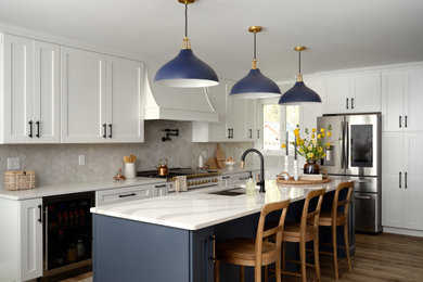 Inspiration for a transitional kitchen remodel in New York with shaker cabinets, blue cabinets and an island