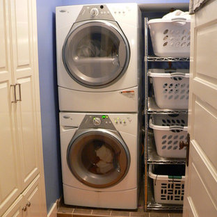 Photo of a small traditional separated utility room in Other with purple walls, light hardwood flooring and a stacked washer and dryer.