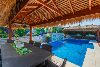 Inspiration for a large tropical backyard rectangular pool in Newcastle - Maitland with a water feature and decking.