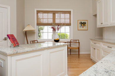 This is an example of a mid-sized beach style single-wall eat-in kitchen in Charleston with recessed-panel cabinets, white cabinets and granite benchtops.